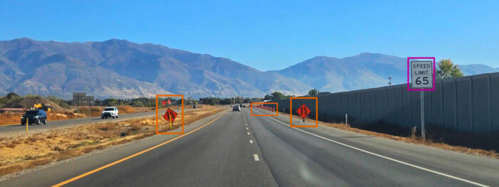 A highway with a speed limit sign of 65 mph, construction warning signs, and mountains in the background highlights the importance of maintaining our Interstate Highways as vital roadway assets.